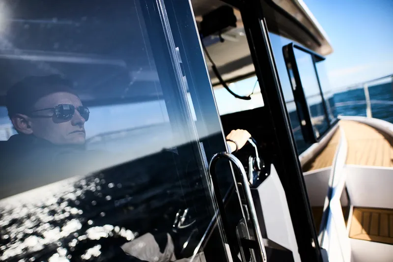 Slide: The Image of Man piloting Northman 1050 boat, 2025 model, with ocean reflection on window. - 33