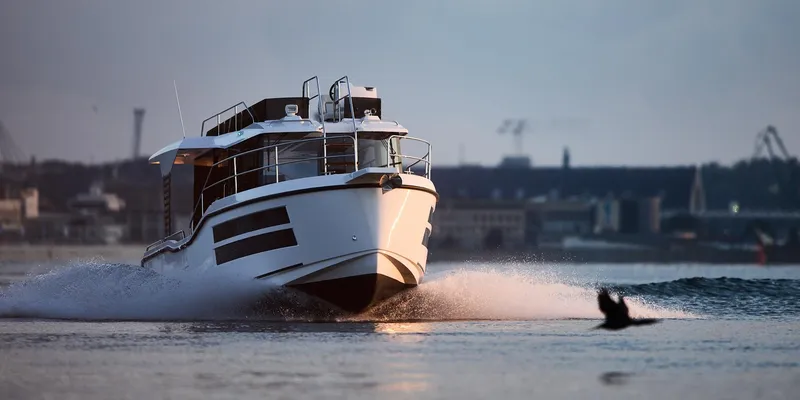 Slide: The Image of Modern Northman 1050 boat cruising on water, 2025 model, cityscape in background. - 9