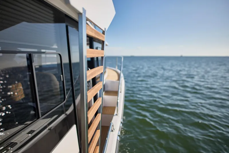 Slide: The Image of Modern Northman 1050 yacht on open water, showcasing sleek design and wooden accents, 2025 model. - 25