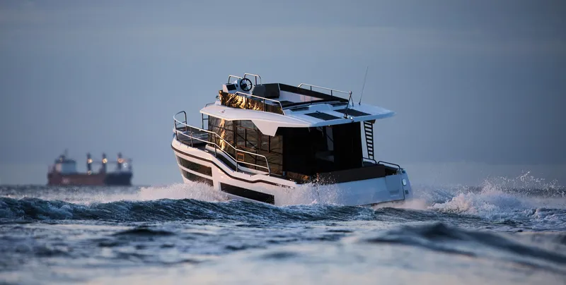 Slide: The Image of Northman 1050 boat cruising on open water, 2025 model, with distant ships in background. - 6