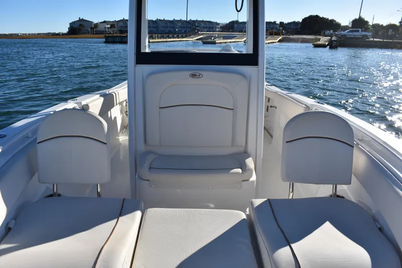 Slide: The Image of 2020 Sea Hunt Ultra 255 SE boat interior with white seating, on calm water. - 10