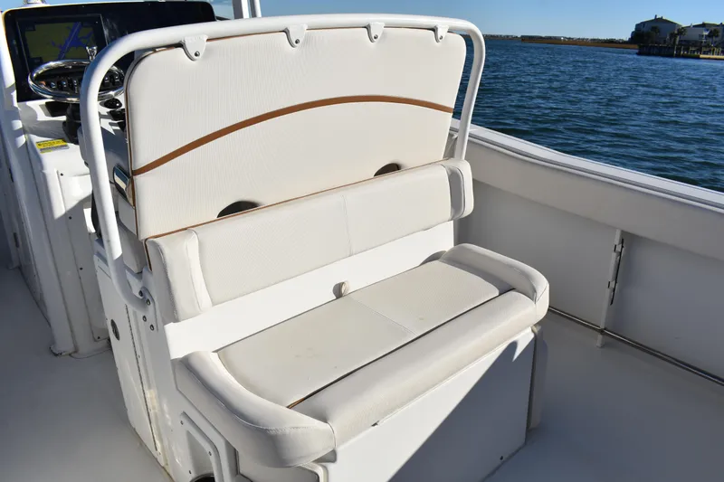 Slide: The Image of 2020 Sea Hunt Ultra 255 SE boat interior with cushioned seating by the water. - 16