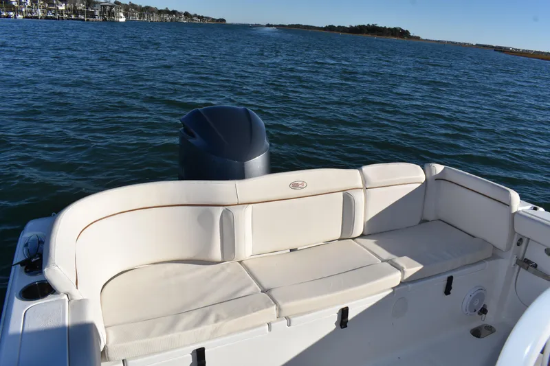 Slide: The Image of 2020 Sea Hunt Ultra 255 SE boat with cushioned seating, on a calm water backdrop. - 18