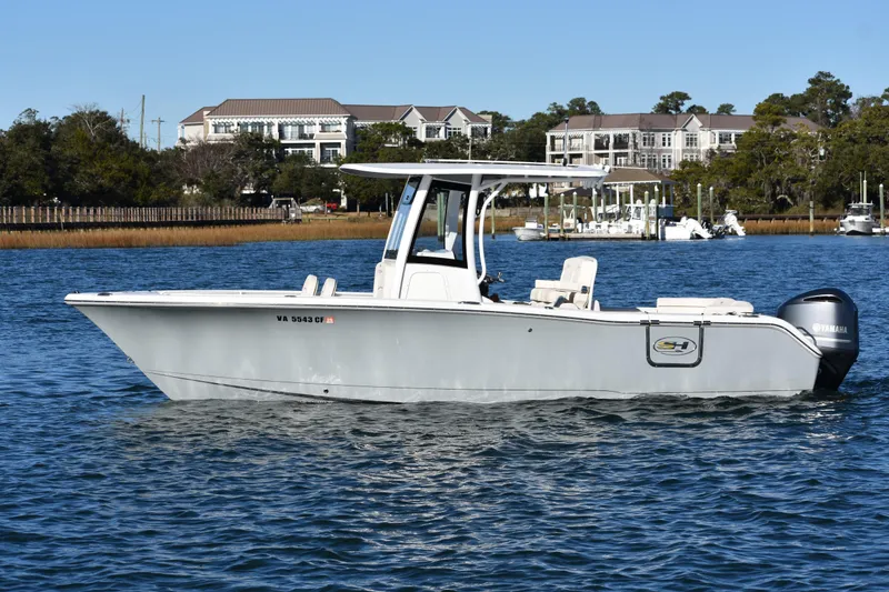 Slide: The Image of 2020 Sea Hunt Ultra 255 SE boat on water, with Yamaha engine, near residential area. - 3