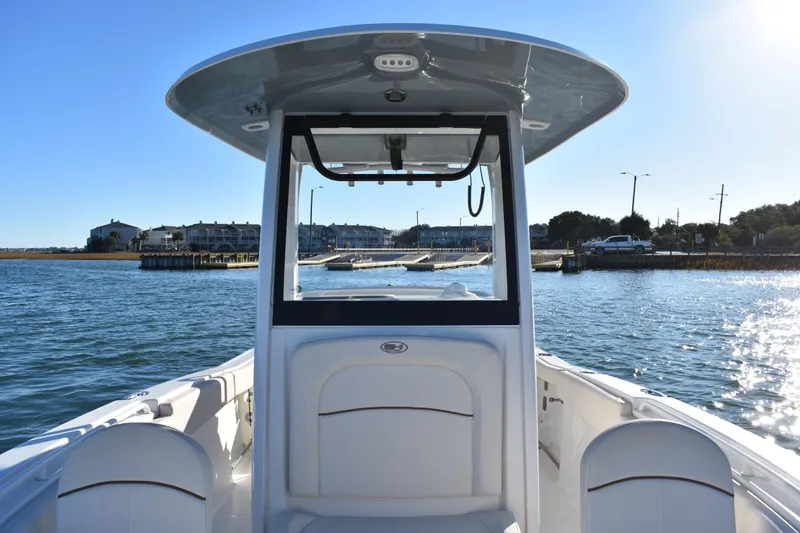 Slide: The Image of 2020 Sea Hunt Ultra 255 SE boat on water near docks and buildings. - 9