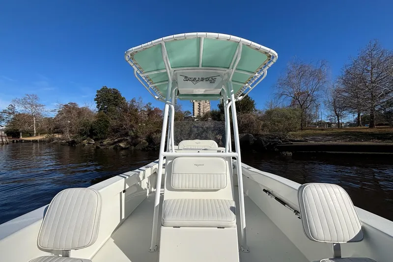 Slide: The Image of 2021 Savannah SS21 boat on calm water, surrounded by trees under a clear blue sky. - 4