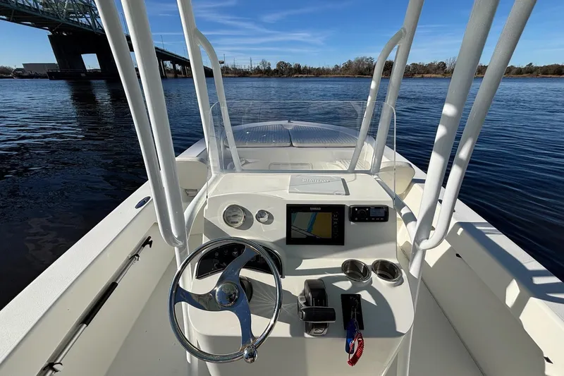 Slide: The Image of 2021 Savannah SS21 boat dashboard with steering wheel and navigation system on a calm river. - 8