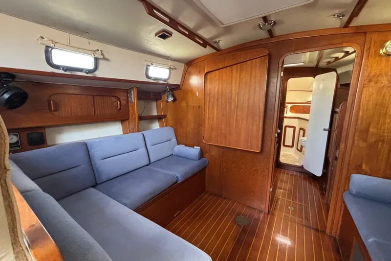 Slide: The Image of Interior of 1997 Caliber 40LRC sailboat with wooden paneling and blue seating. - 21