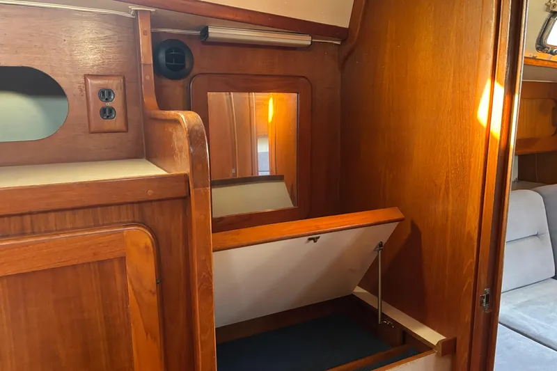 Slide: The Image of Wooden interior of a 1997 Caliber 40LRC sailboat with storage and mirror. - 23