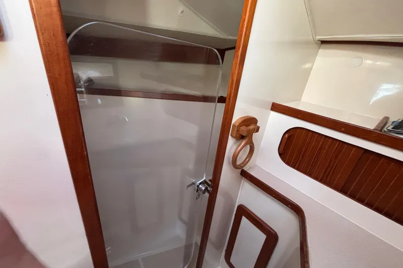 Slide: The Image of Interior of 1997 Caliber 40LRC yacht featuring a wooden-trimmed shower area. - 26