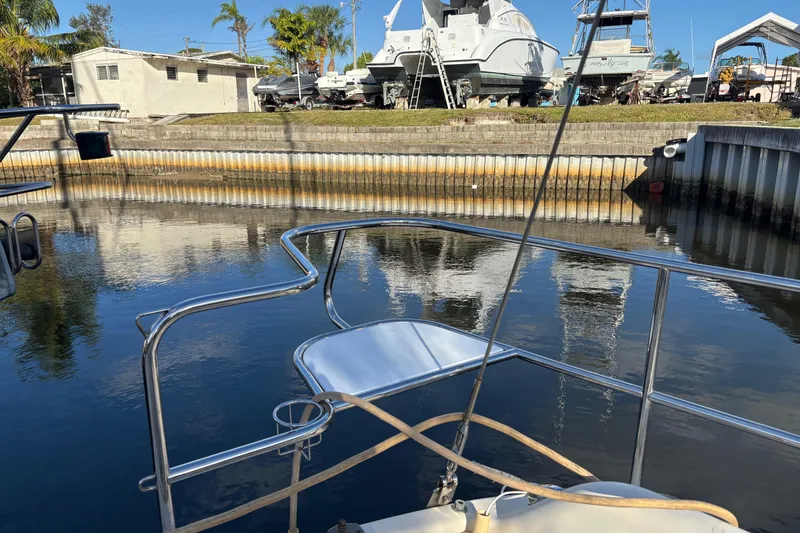 Slide: The Image of Bow of 1997 Caliber 40LRC yacht in a marina with boats and palm trees. - 3