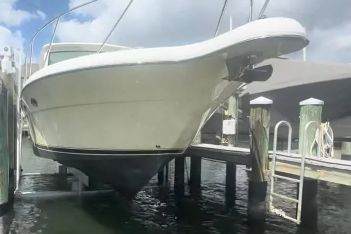 Slide: The Image of 2007 Tiara Yachts 3000 Open on lift, docked in marina under clear blue sky. - 2