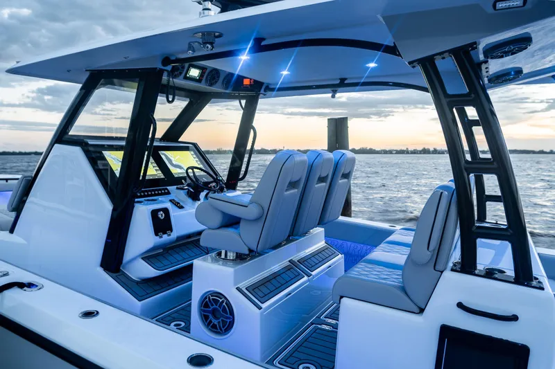 Slide: The Image of 2026 Barker Boatworks 40HPC interior with modern helm and seating at sunset. - 12