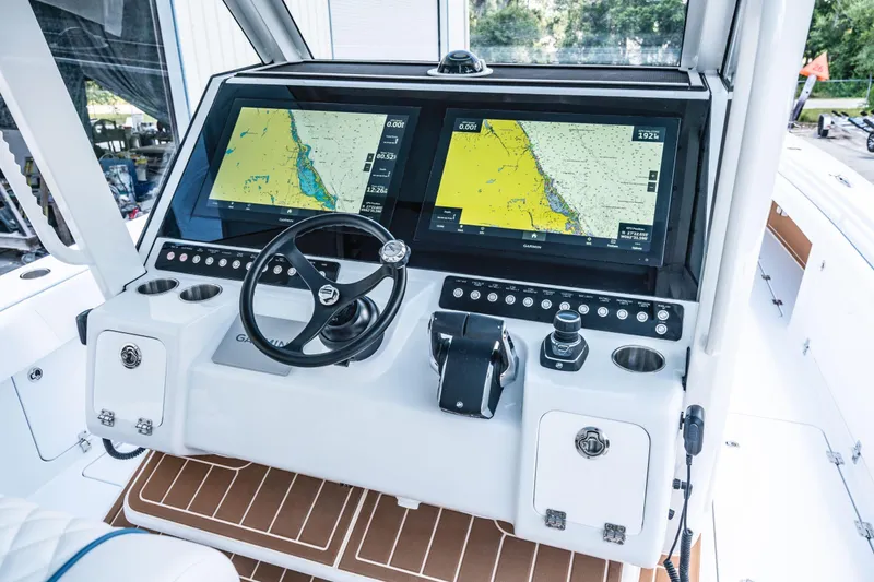 Slide: The Image of 2026 Barker Boatworks 40HPC helm with dual Garmin navigation displays and steering wheel. - 15