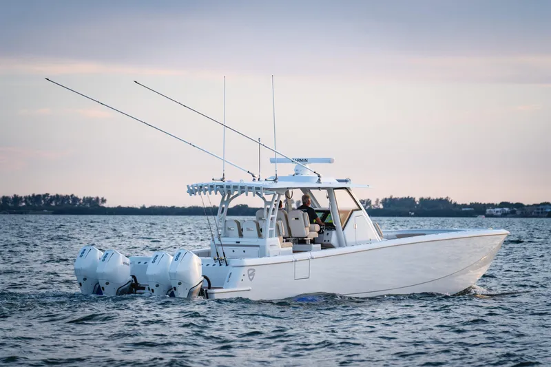 Slide: The Image of 2026 Barker Boatworks 40HPC cruising on water near urban skyline and palm trees. - 2