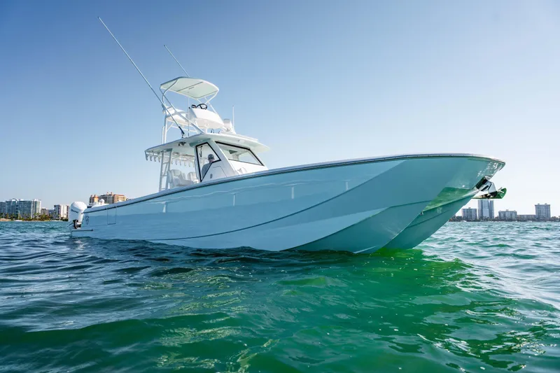 Slide: The Image of 2026 Barker Boatworks 40HPC cruising on clear blue water near city skyline. - 35