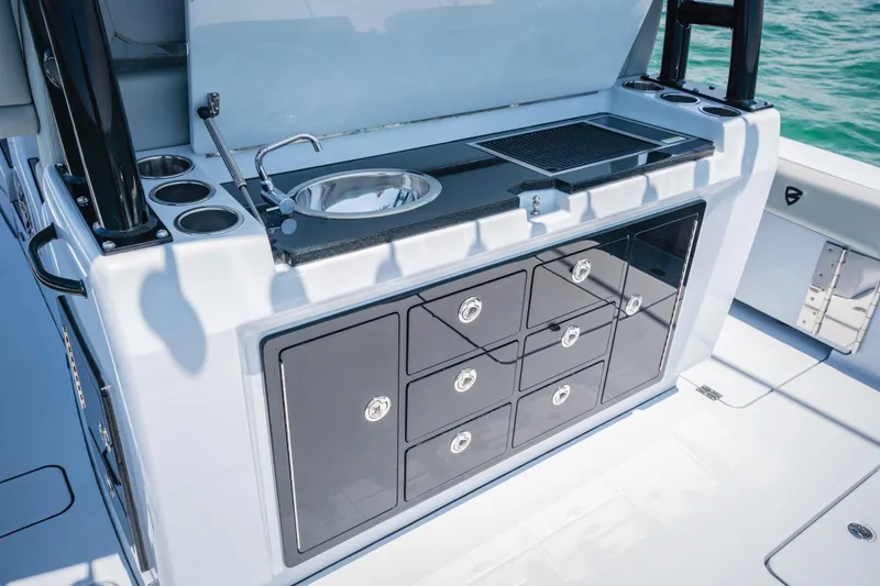 Slide: The Image of 2026 Barker Boatworks 40HPC outdoor kitchen with sink, grill, and storage drawers. - 8