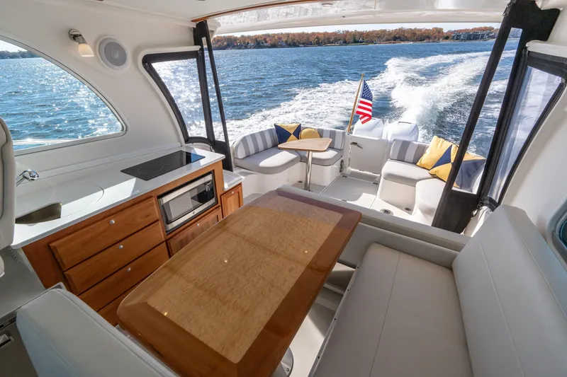Slide: The Image of Interior of 2023 Back Cove 340 yacht with kitchen and seating area on water. - 15
