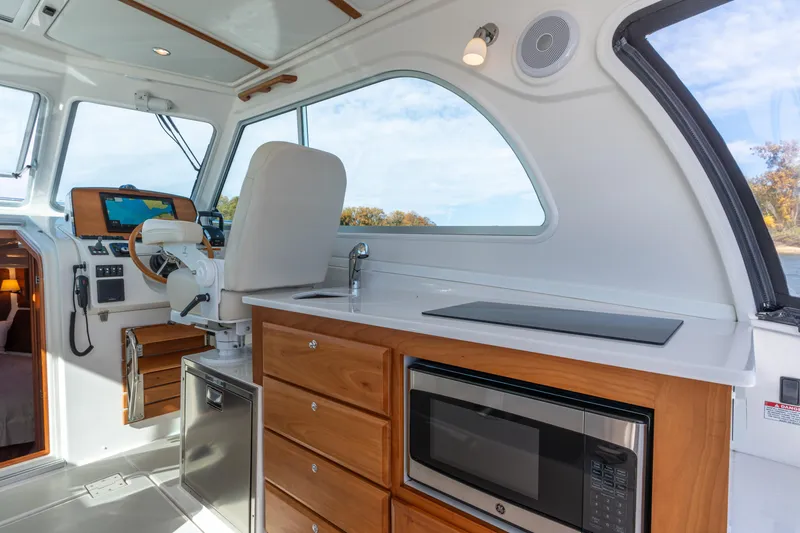 Slide: The Image of 2023 Back Cove 340 interior with helm, kitchenette, and modern amenities. - 17