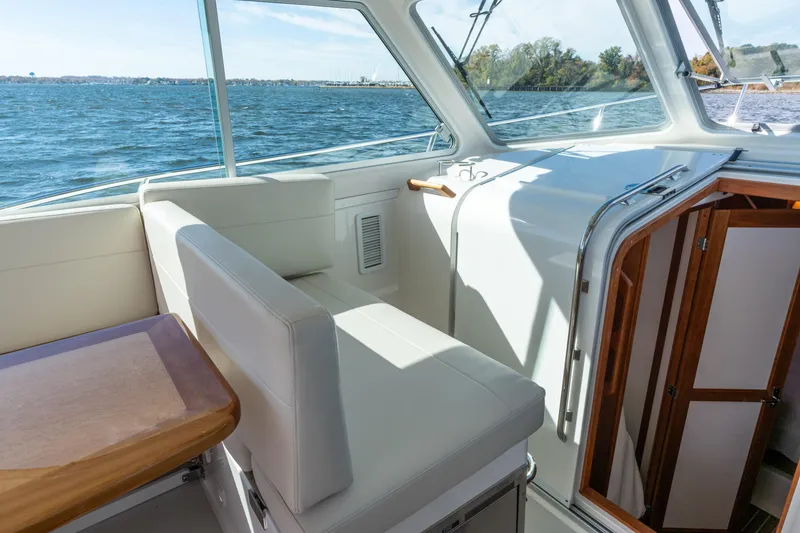 Slide: The Image of Interior of 2023 Back Cove 340 boat with white seating and wooden accents. - 18