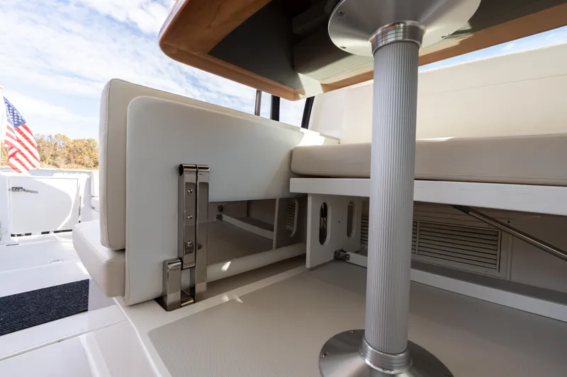 Slide: The Image of 2023 Back Cove 340 boat interior with seating and table, featuring an American flag. - 20