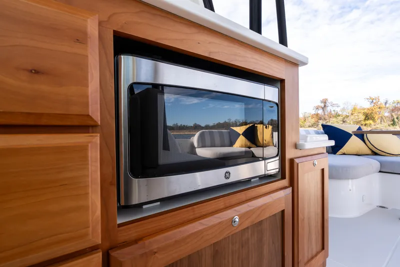 Slide: The Image of 2023 Back Cove 340 yacht interior with microwave and stylish seating area. - 34