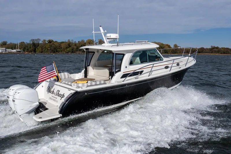 Slide: The Image of 2023 Back Cove 340 boat cruising on water with American flag. - 4