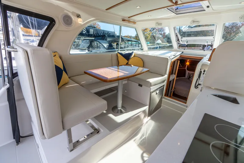 Slide: The Image of 2023 Back Cove 340 interior with dining area, modern seating, and large windows. - 40