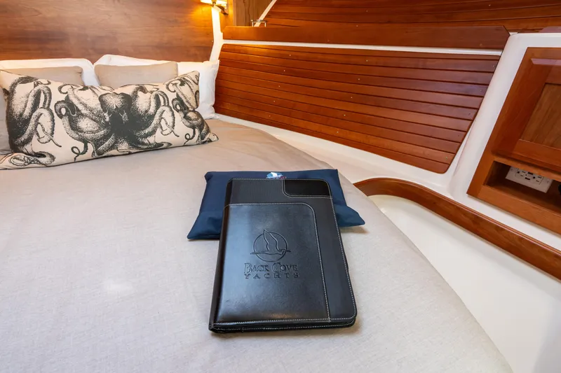 Slide: The Image of 2023 Back Cove 340 yacht cabin with octopus pillow and branded folder on bed. - 51