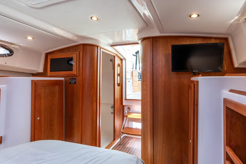 Slide: The Image of 2023 Back Cove 340 interior with wood paneling, TV, and modern lighting. - 53