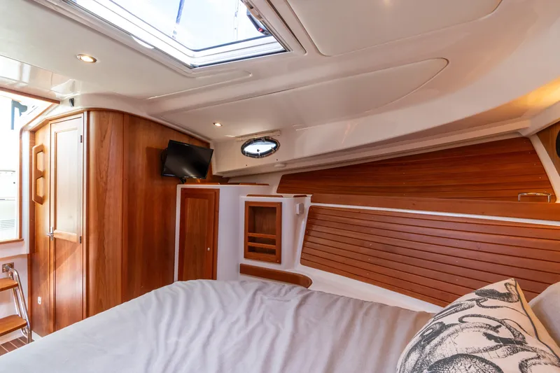 Slide: The Image of 2023 Back Cove 340 cabin interior with wood paneling and skylight. - 54