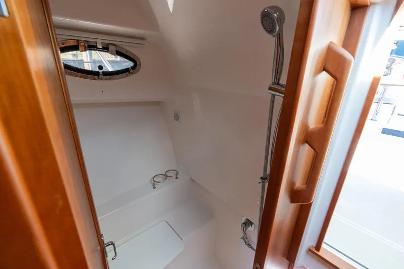 Slide: The Image of 2023 Back Cove 340 boat interior with shower and wooden accents. - 57