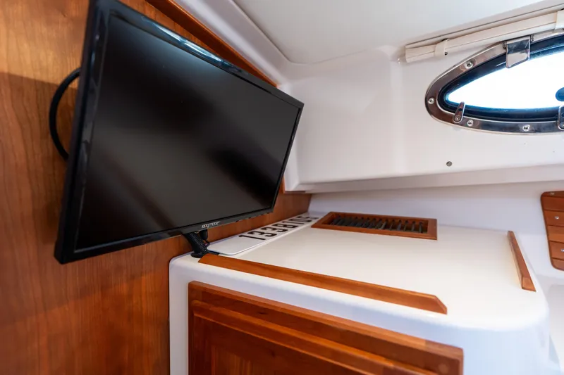 Slide: The Image of 2023 Back Cove 340 interior with mounted TV and porthole window. - 63