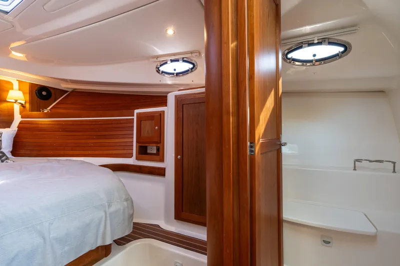 Slide: The Image of 2023 Back Cove 340 cabin interior with wood paneling and cozy bed. - 66