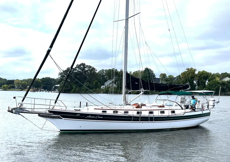 Slide: The Image of 1996 Gozzard 44 AC sailboat on calm water, surrounded by trees. - 2