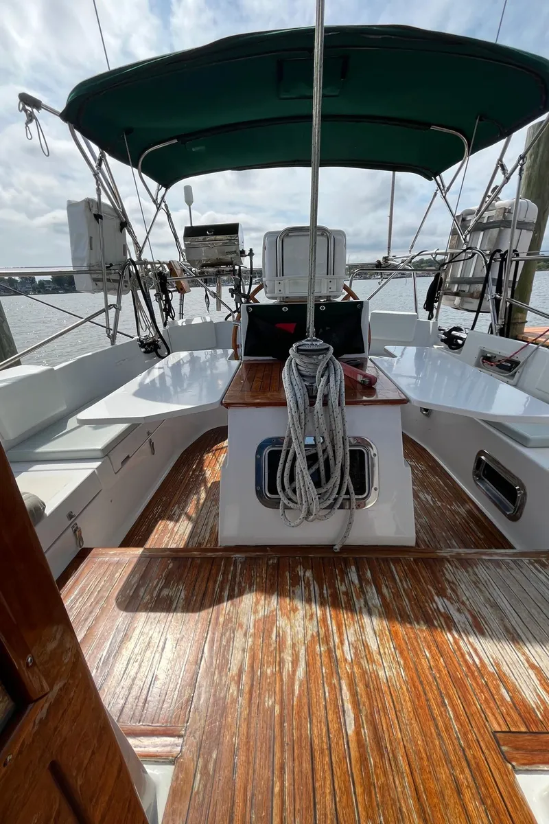 Slide: The Image of 1996 Gozzard 44 AC sailboat cockpit with wooden deck and green canopy. - 23