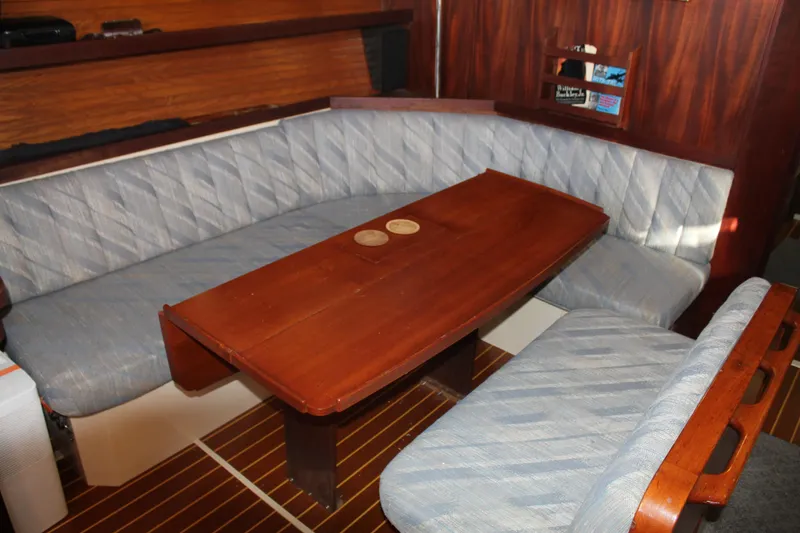 Slide: The Image of Interior of 1990 Catalina 42 sailboat with wooden table and cushioned seating. - 27