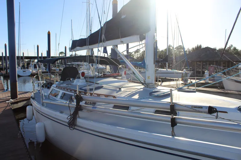 Slide: The Image of 1990 Catalina 42 sailboat docked at marina, sunlit with clear sky. - 2