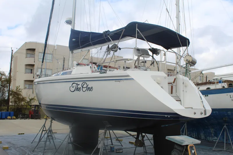 Slide: The Image of 1990 Catalina 42 sailboat named "The One" on dry dock with blue canopy. - 53