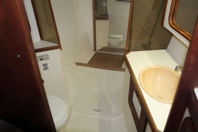 Slide: The Image of Interior of 1990 Catalina 42 sailboat bathroom with sink, toilet, and wooden accents. - 16