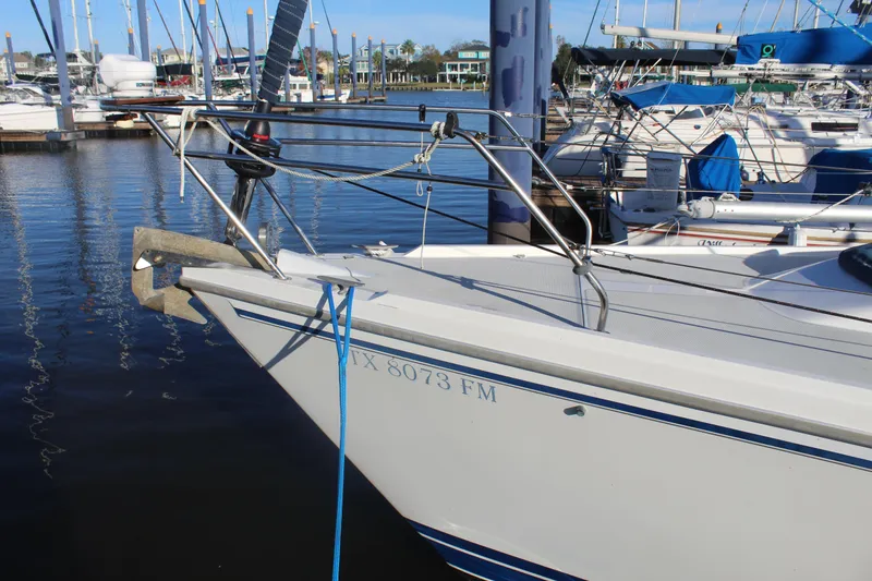 Slide: The Image of 1990 Catalina 42 sailboat docked at marina, featuring bow and anchor. - 44