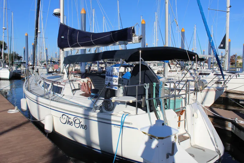 Slide: The Image of Sailboat "The One" docked, Catalina 42 model, 1990, in a marina under clear blue skies. - 1