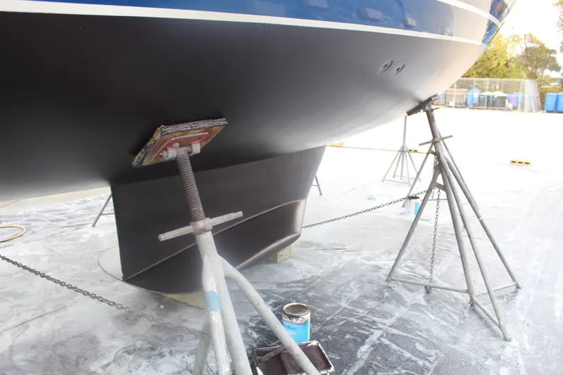Slide: The Image of Catalina 42 sailboat from 1990 on stands, undergoing maintenance in a boatyard. - 55