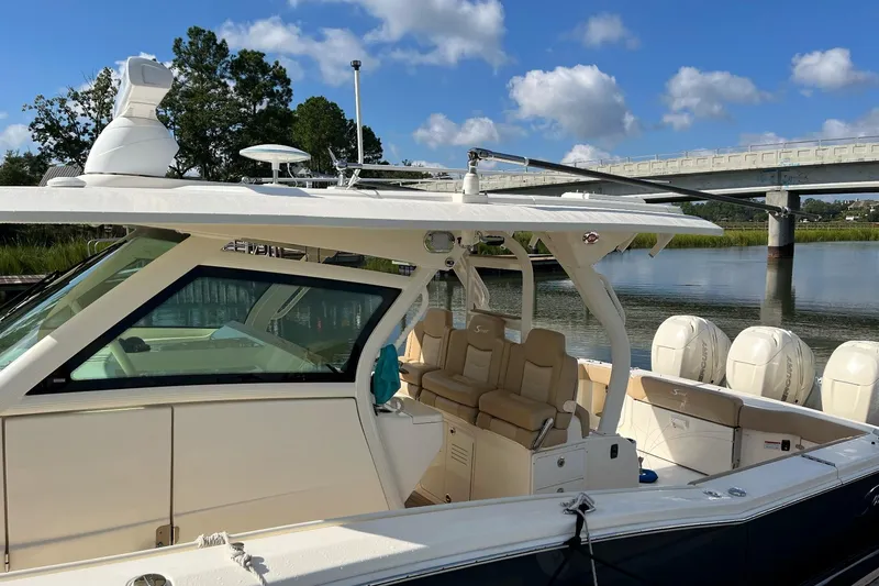 Slide: The Image of 2019 Scout 380 LXF boat docked by a scenic river with clear skies. - 5