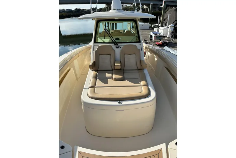 Slide: The Image of 2019 Scout 380 LXF boat with beige seating, docked near calm water. - 9
