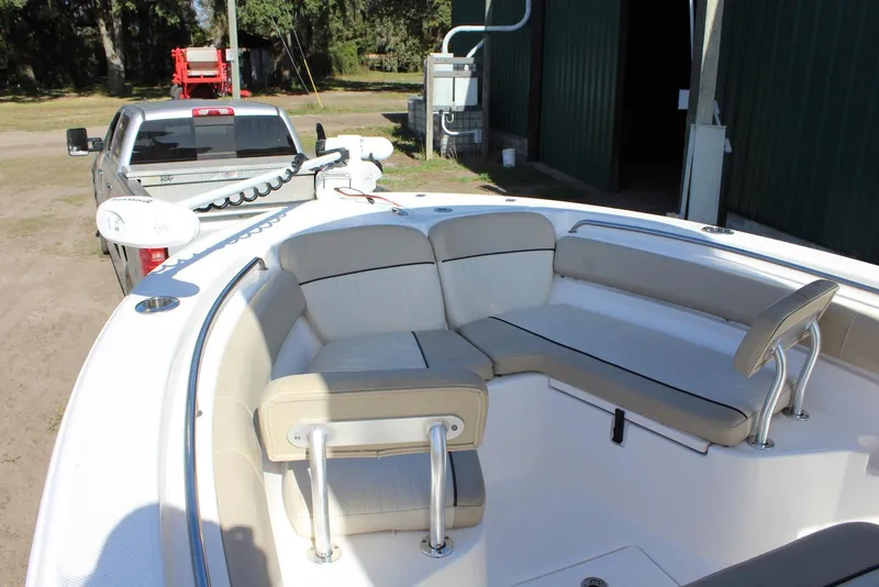 Slide: The Image of 2018 Sea Fox 226 Commander boat interior with beige seating, parked near a truck. - 12