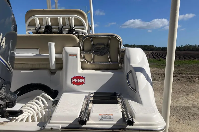 Slide: The Image of 2018 Sea Fox 226 Commander boat with Yamaha engine, ladder, and Penn sticker, under blue sky. - 20