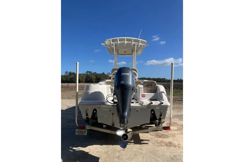 Slide: The Image of 2018 Sea Fox 226 Commander boat with Yamaha 200 engine, parked on land under clear blue sky. - 21