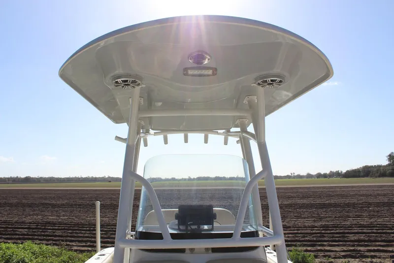 Slide: The Image of 2018 Sea Fox 226 Commander boat with T-top, set against a clear sky. - 24