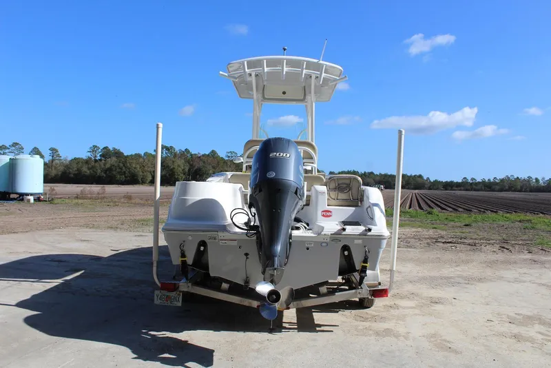 Slide: The Image of 2018 Sea Fox 226 Commander boat with Yamaha 200 engine, parked outdoors under blue sky. - 25